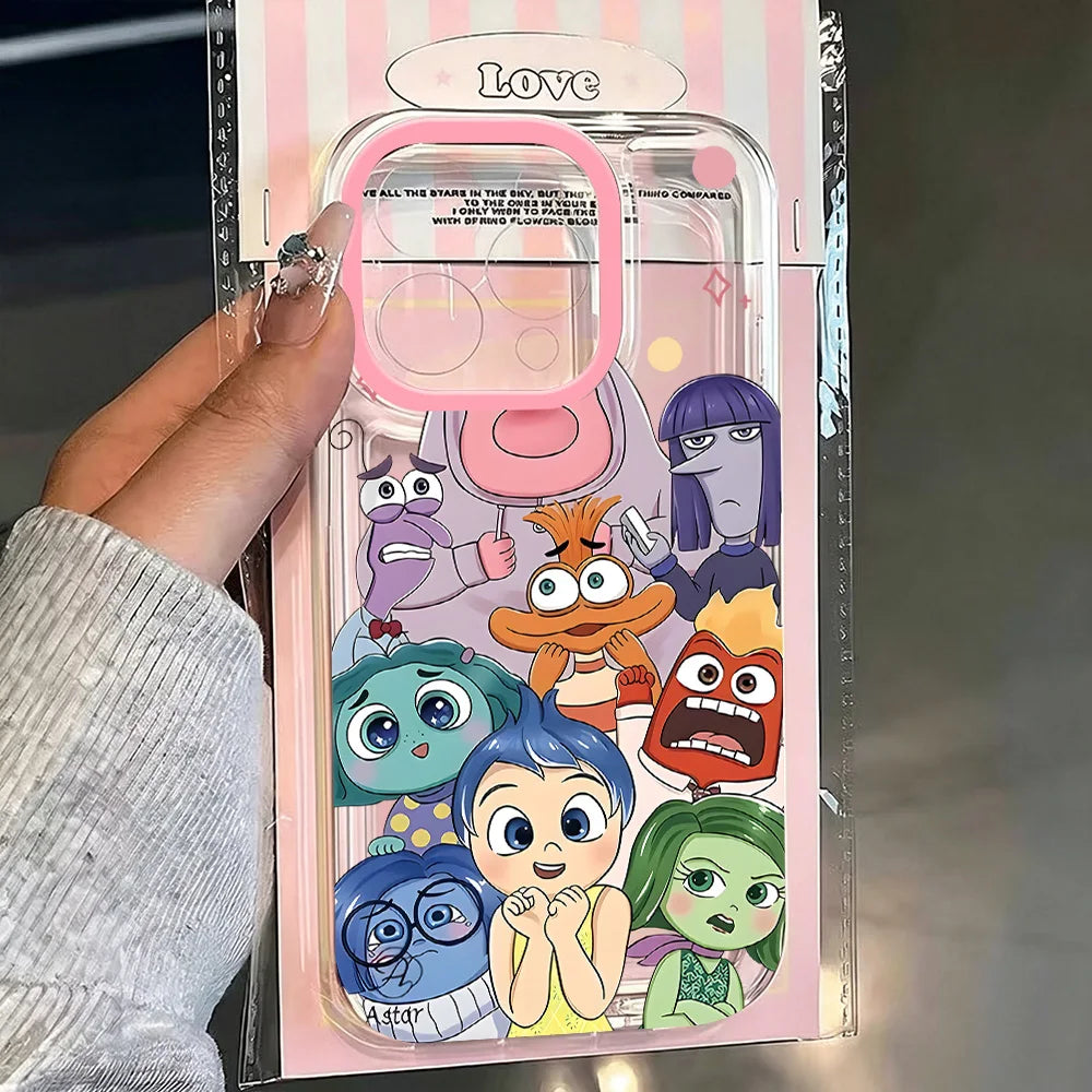 A hand holds a clear phone case with a pink camera ring and colorful cartoon characters printed on the back, still inside its pink striped retail packaging. The case features characters resembling Joy, Sadness, Fear, Anger, Disgust, and Boredom from Inside Out.
