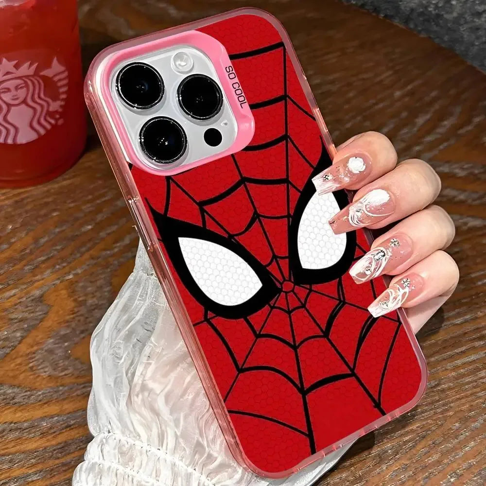A clear phone case with a red and black Spider-Man web pattern and large white eyes, held by a hand with decorated nails over a wooden table.