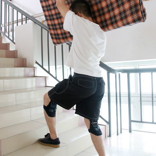 Man carrying a heavy load upstairs while wearing joint support knee pads for pain relief