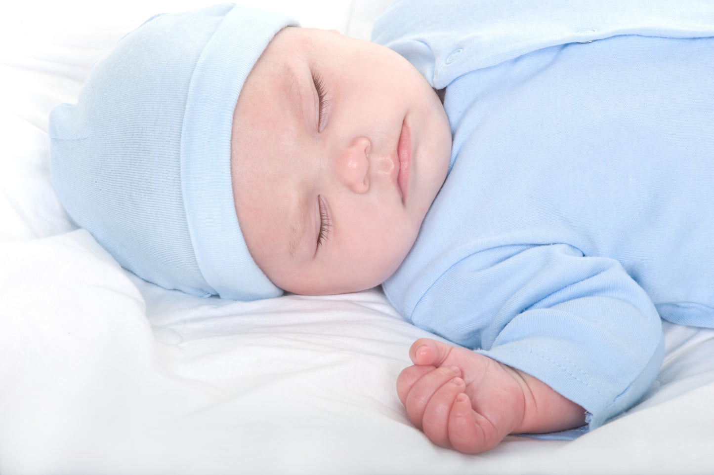 Emerald Clover newborn baby boy layette set soft blue sleeper and hat on sleeping infant