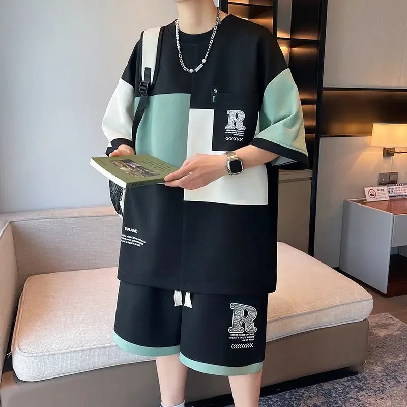 Streetwear model wearing black mint green colorblock coordinated outfit and shorts from trendy men's clothing sets collection