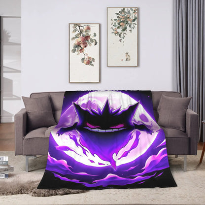 A throw blanket featuring a large anime-style purple and black monster face design is draped over a gray sofa in a living room setting.