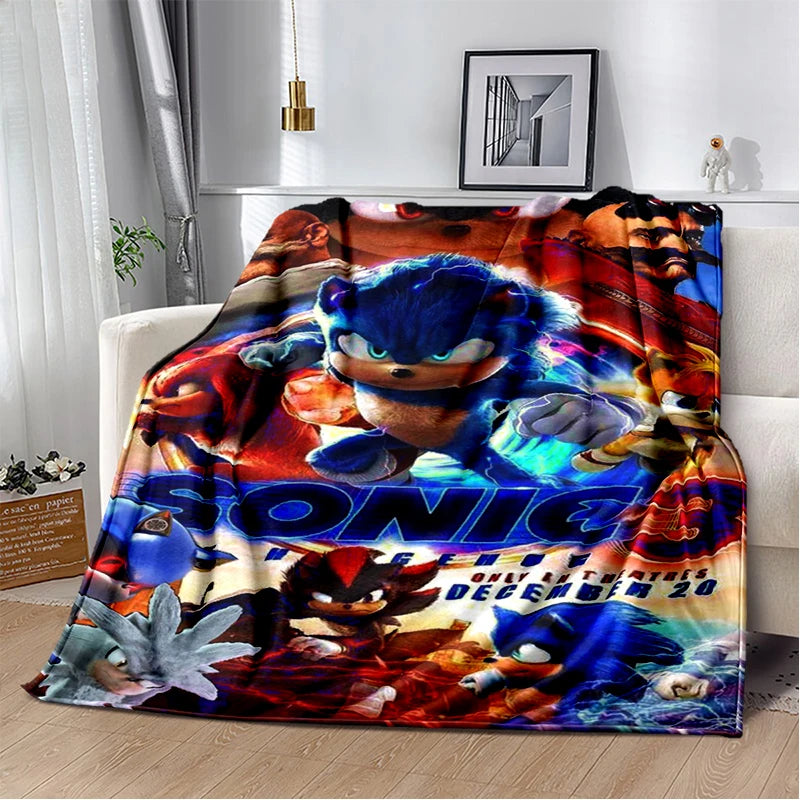 A colorful throw blanket featuring Sonic the Hedgehog artwork draped over a white sofa in a living room setting.