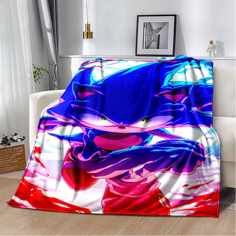 A colorful throw blanket featuring Sonic the Hedgehog artwork, draped over a white sofa in a modern living room setting.