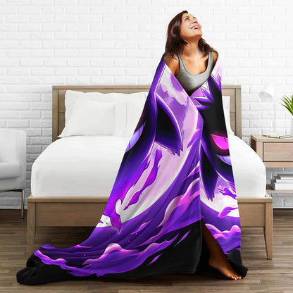 A woman wrapped in a large purple and black abstract blanket standing in front of a bed in a modern bedroom setting.