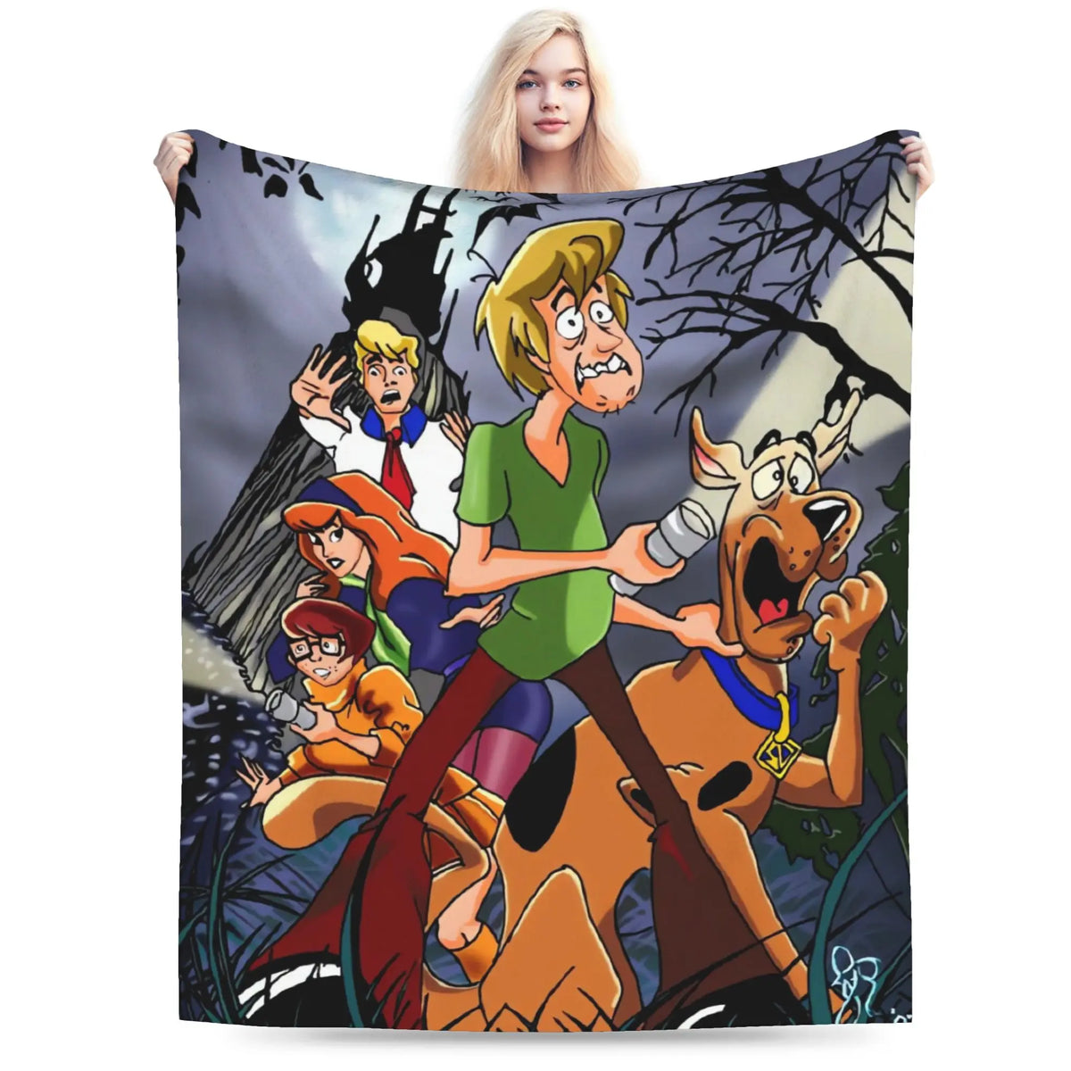 A person holding up a large printed blanket or tapestry featuring the Scooby-Doo cartoon characters against a dark spooky forest scene, photographed on a plain white background.