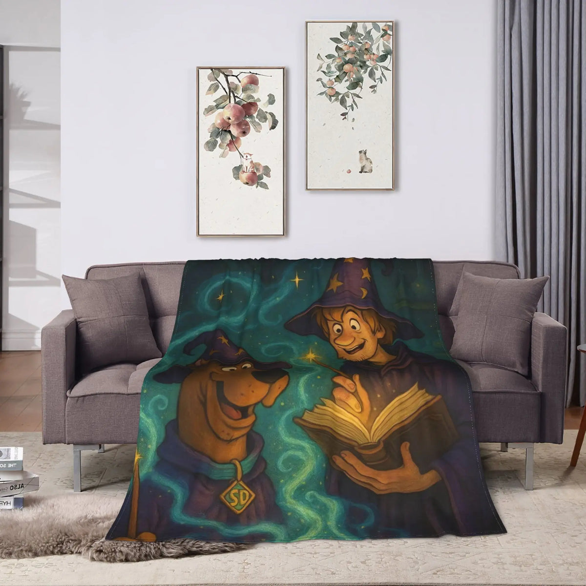 A cozy living room scene with a gray sofa draped in a printed blanket featuring two cartoon characters in wizard hats reading a glowing book, surrounded by swirling teal magic. The room has two framed floral prints on the wall, gray curtains, and a light rug.