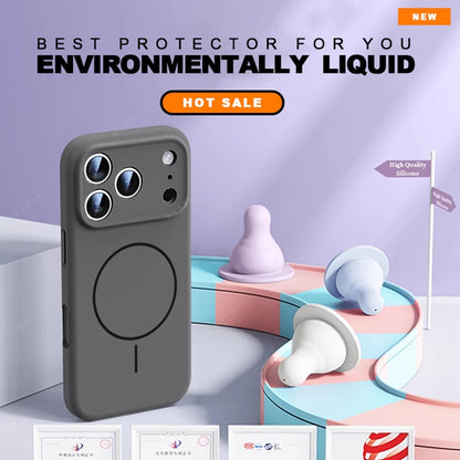 A dark gray magnetic phone case with a circular MagSafe ring, shown on a smartphone. The background is a stylized studio setup with pastel pink, blue, and purple display platforms, decorative silicone objects, and promotional text overlays including 'NEW' and 'ENVIRONMENTALLY LIQUID'.