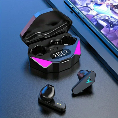 Black wireless earbuds with charging case on a blue surface, next to a smartphone displaying a game.