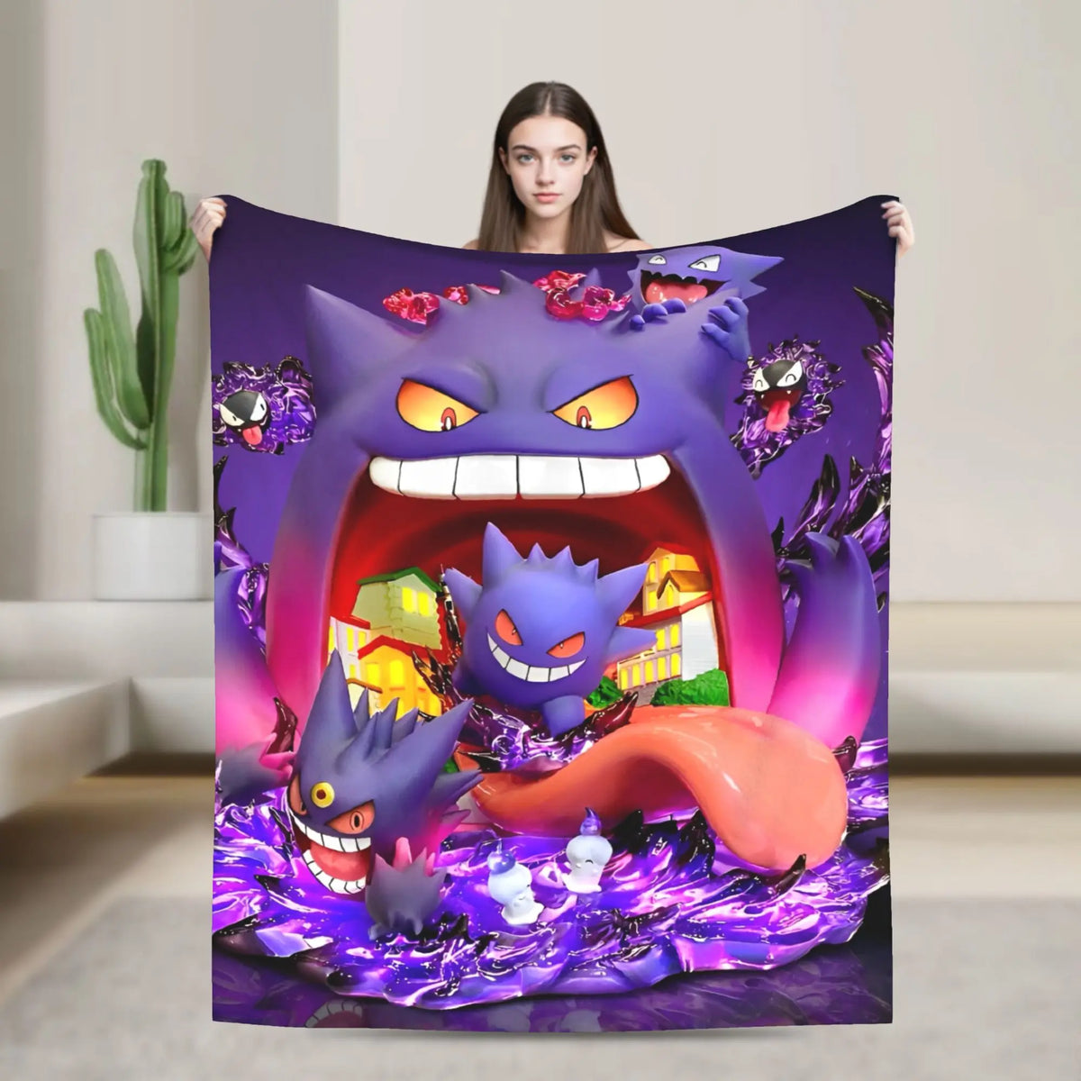 A woman holds up a large printed blanket or tapestry featuring cartoon Pokémon Gengar characters in a purple scene, shown against a neutral indoor room background.