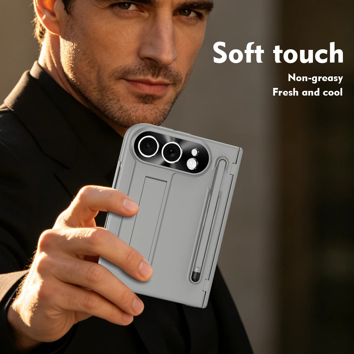 A man in a black suit holds a light gray smartphone case with a built-in stylus and camera cutout. The image includes text overlays reading 'Soft touch', 'Non-greasy', and 'Fresh and cool' on a softly blurred dark background.