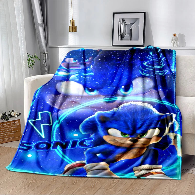 A blue throw blanket featuring Sonic the Hedgehog artwork draped over a white sofa in a modern living room setting.