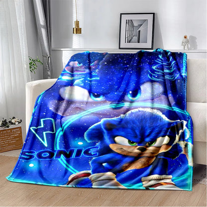 A blue throw blanket featuring Sonic the Hedgehog artwork draped over a white sofa in a modern living room setting.