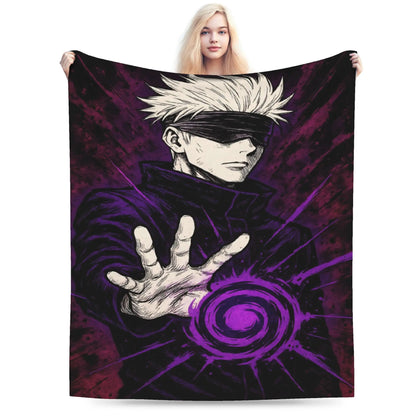 A woman holds up a large blanket or tapestry featuring an anime-style illustration of a blindfolded character with spiky white hair extending a hand forward, surrounded by a purple swirl effect on a dark background. The blanket is photographed against a plain white studio background.