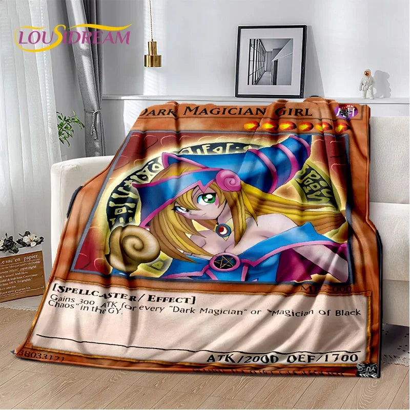 A plush throw blanket featuring Yu-Gi-Oh! anime artwork of the Dark Magician Girl, styled draped over a white sofa in a modern living room setting.