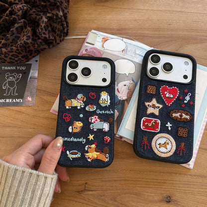 Two black phone cases with colorful designs held by a hand on a wooden surface.