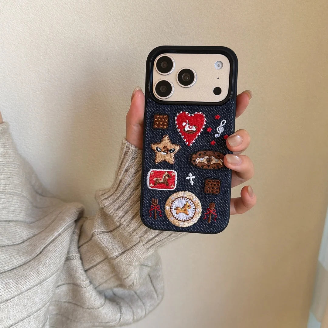 Phone case with various patches held by a person against a neutral background
