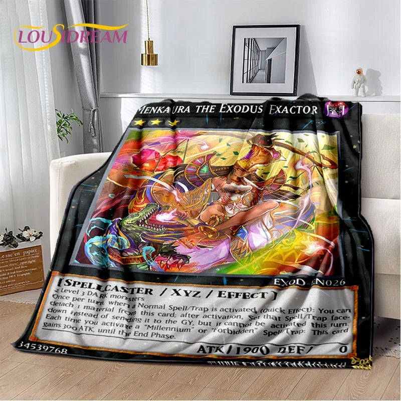 A plush blanket featuring a colorful Yu-Gi-Oh! card art print of 'Menza Ira the Exodus Exactor', draped over a white sofa in a modern living room setting.