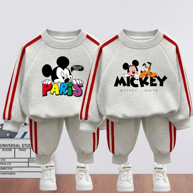 Two children's sweatshirt and pants sets with Mickey Mouse design on a light gray background.