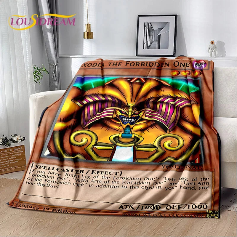 A colorful printed blanket or throw draped over a white sofa in a living room setting. The design features a fantasy illustration with the text 'EXODUS THE FORBIDDEN ONE' and a spellcard-style lower section.