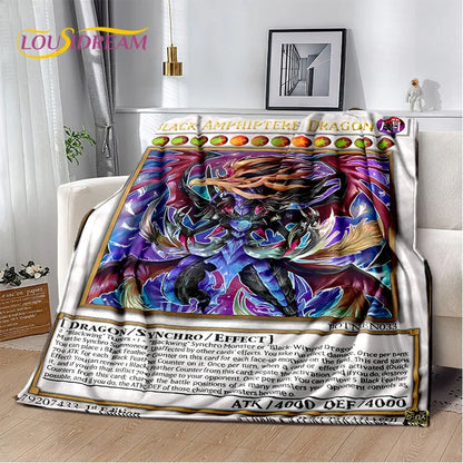 A plush throw blanket featuring a colorful 'Black Amphiptere Dragon' Yu-Gi-Oh! card design, draped over a white armchair in a modern living room setting.