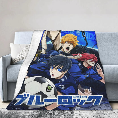 A fleece throw blanket featuring anime characters from Blue Lock, draped over a gray sofa in a living room setting.