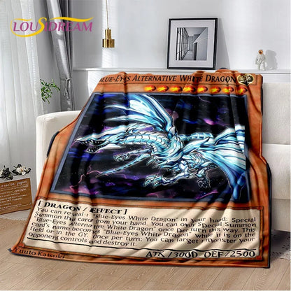 A plush throw blanket featuring a Yu-Gi-Oh! Blue-Eyes Alternative White Dragon card design, draped over a white armchair in a modern living room setting.