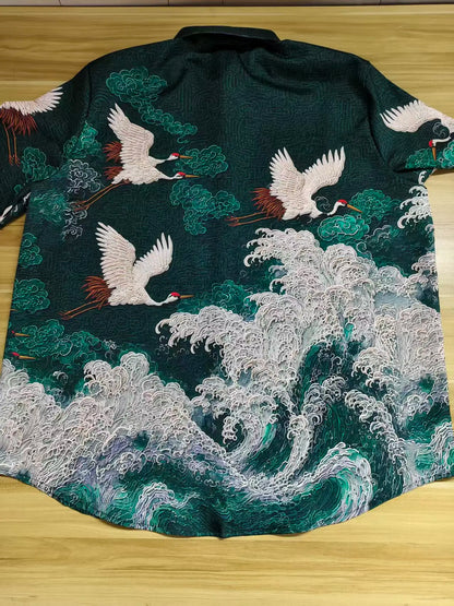 Embroidered garment with cranes and wave design on a wooden surface