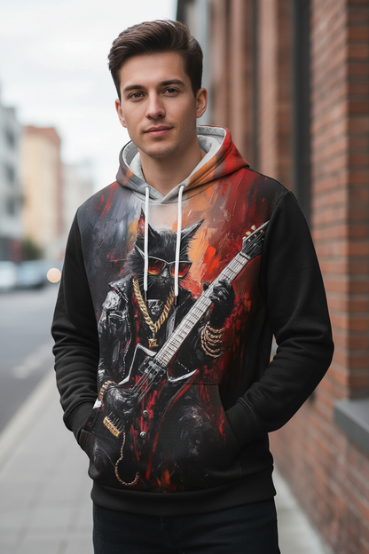 A young man wearing a black hoodie with a large graphic print of a cat playing an electric guitar, standing on a city street next to a brick building.