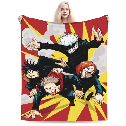 A person holds up a large printed blanket or tapestry featuring four anime characters in dynamic poses over a red and yellow burst background. The person is partially visible behind the blanket, and the blanket fills most of the frame against a plain light background.