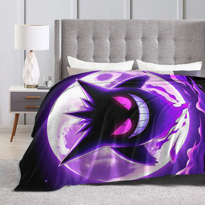 A bed in a modern bedroom setting with a gray tufted headboard and bedside table, featuring a vibrant purple and black anime-style blanket with a crescent moon and star design.