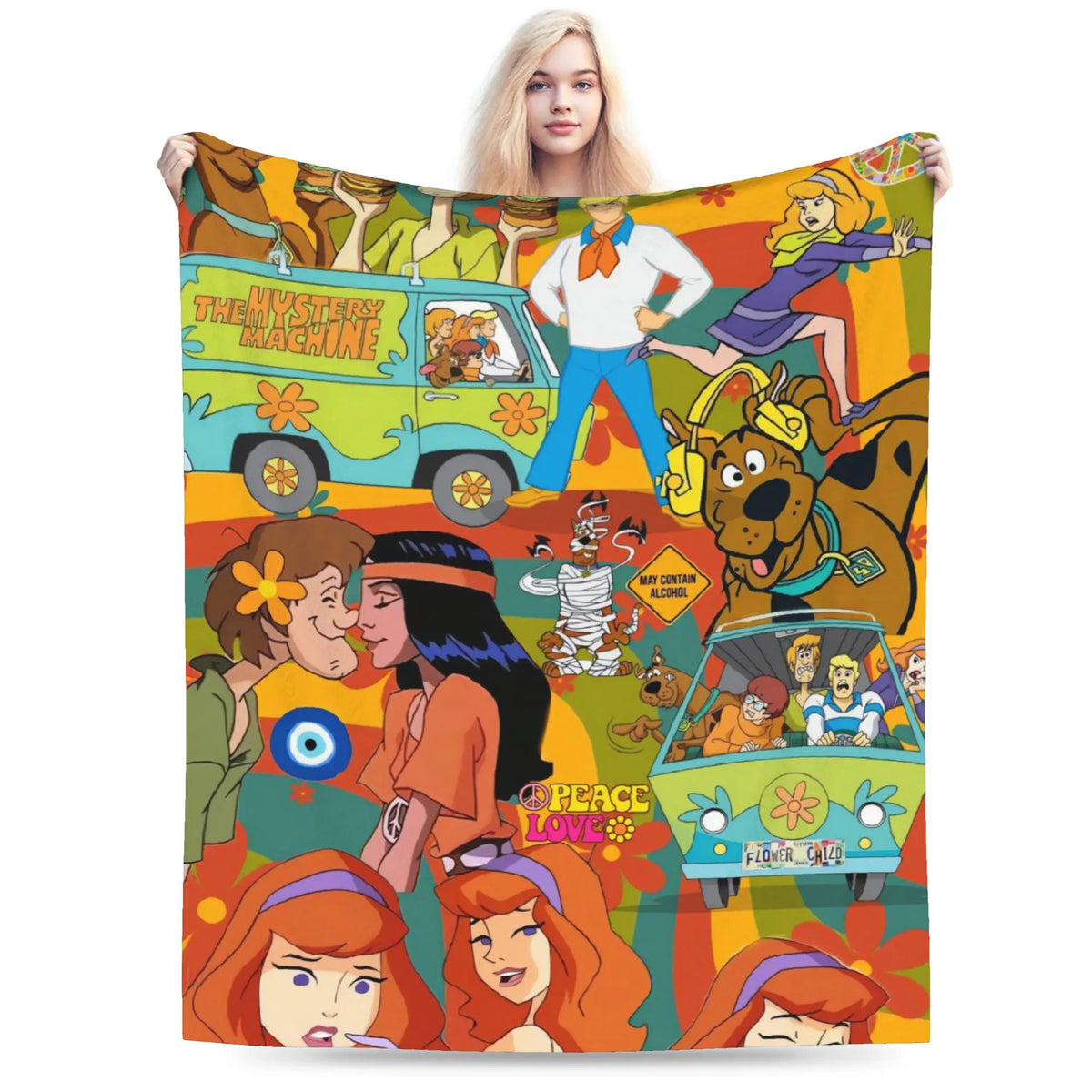 A woman holds up a large fleece blanket featuring a colorful retro collage of The Mystery Machine and Scooby-Doo characters, including Fred, Daisy, Shag, and Velma, in a vibrant 1960s-1970s psychedelic style.