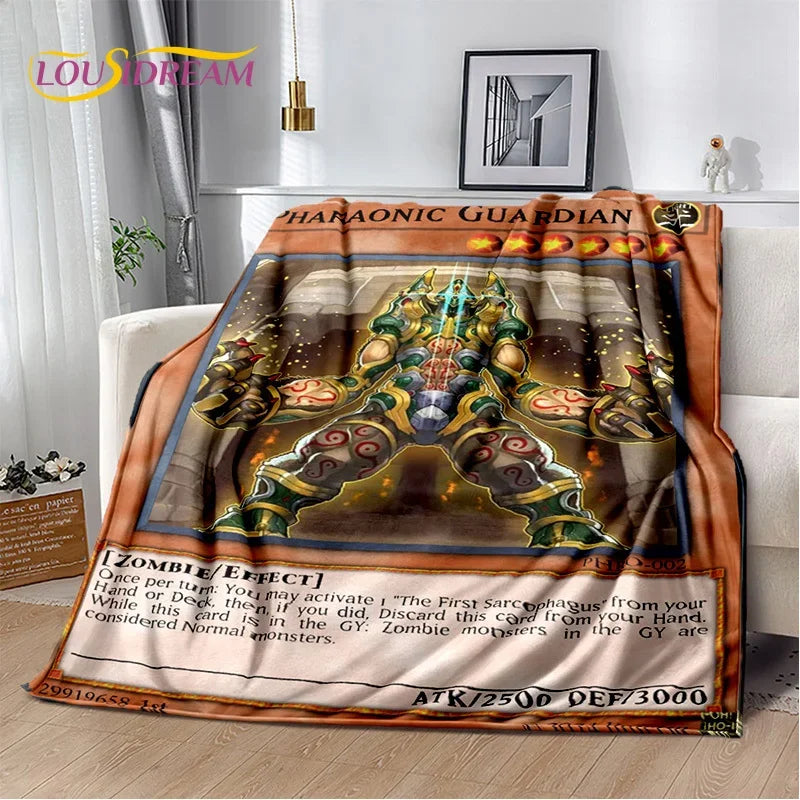 A plush fleece blanket featuring a Pokémon-style card design with the text 'HARMOONIC GUARDIAN' and an illustration of a green armored character, draped over a white sofa in a living room setting.