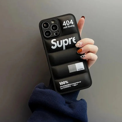 Phone case with 'Supreme' branding held by a hand against a gray background