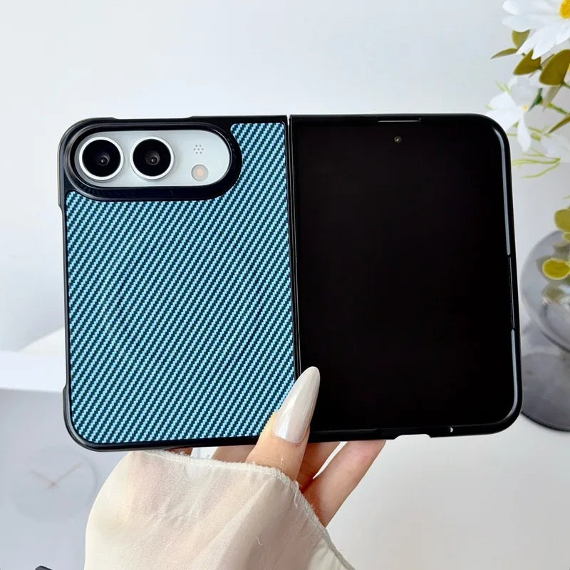 A person holds a foldable smartphone case open to show both sides. The back side has a blue and black diagonal carbon-fiber-style pattern, while the front cover is solid black.