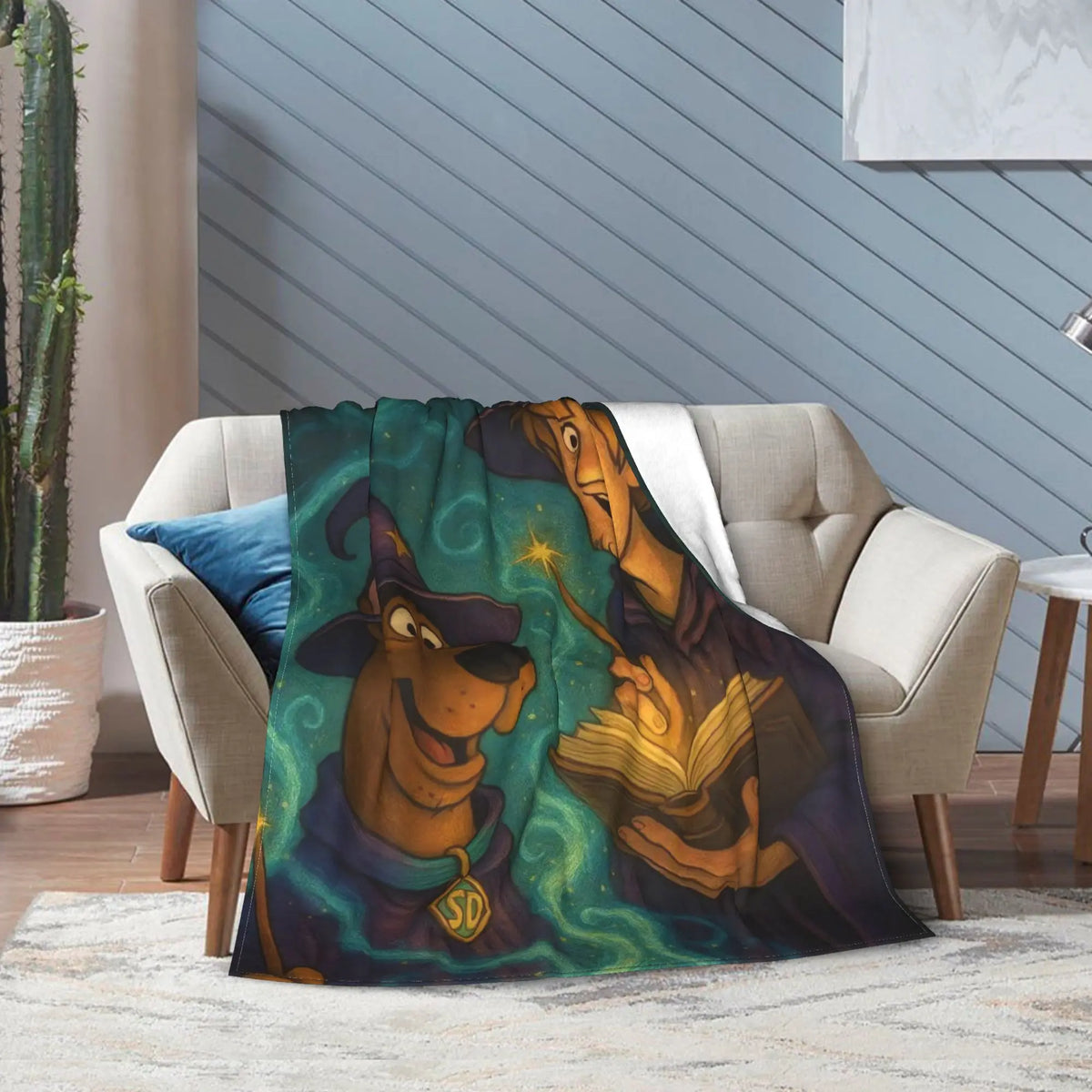 A cozy living room scene with a beige armchair draped in a printed throw blanket featuring Scooby-Doo and a wizard holding a glowing book against a swirling teal background.
