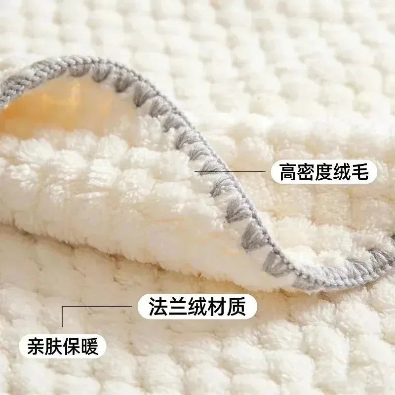 Close-up of a soft white plush blanket or mattress topper with a folded corner showing a gray braided edge. Chinese text labels are overlaid pointing to dense plush fibers and French terry material.