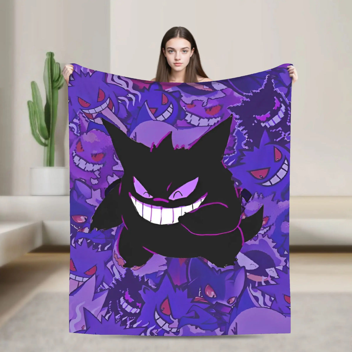 A woman holds up a large blanket featuring a repeating purple and black Gengar pattern, set against a modern, minimalist beige interior background.