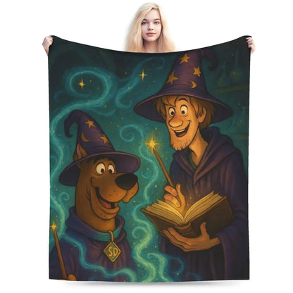 A person holds up a large printed blanket or tapestry featuring Scooby-Doo and a wizard character against a dark magical background. The product is shown against a plain white studio background, with the model only partially visible behind it.