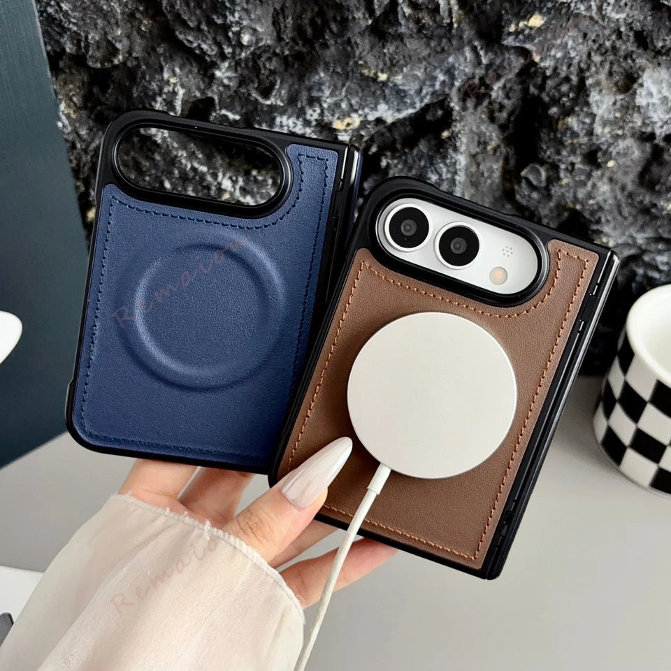 Two leather phone cases held in a hand, one in navy blue and one in brown, both with black camera bezels and MagSafe rings, against a dark textured rock background.