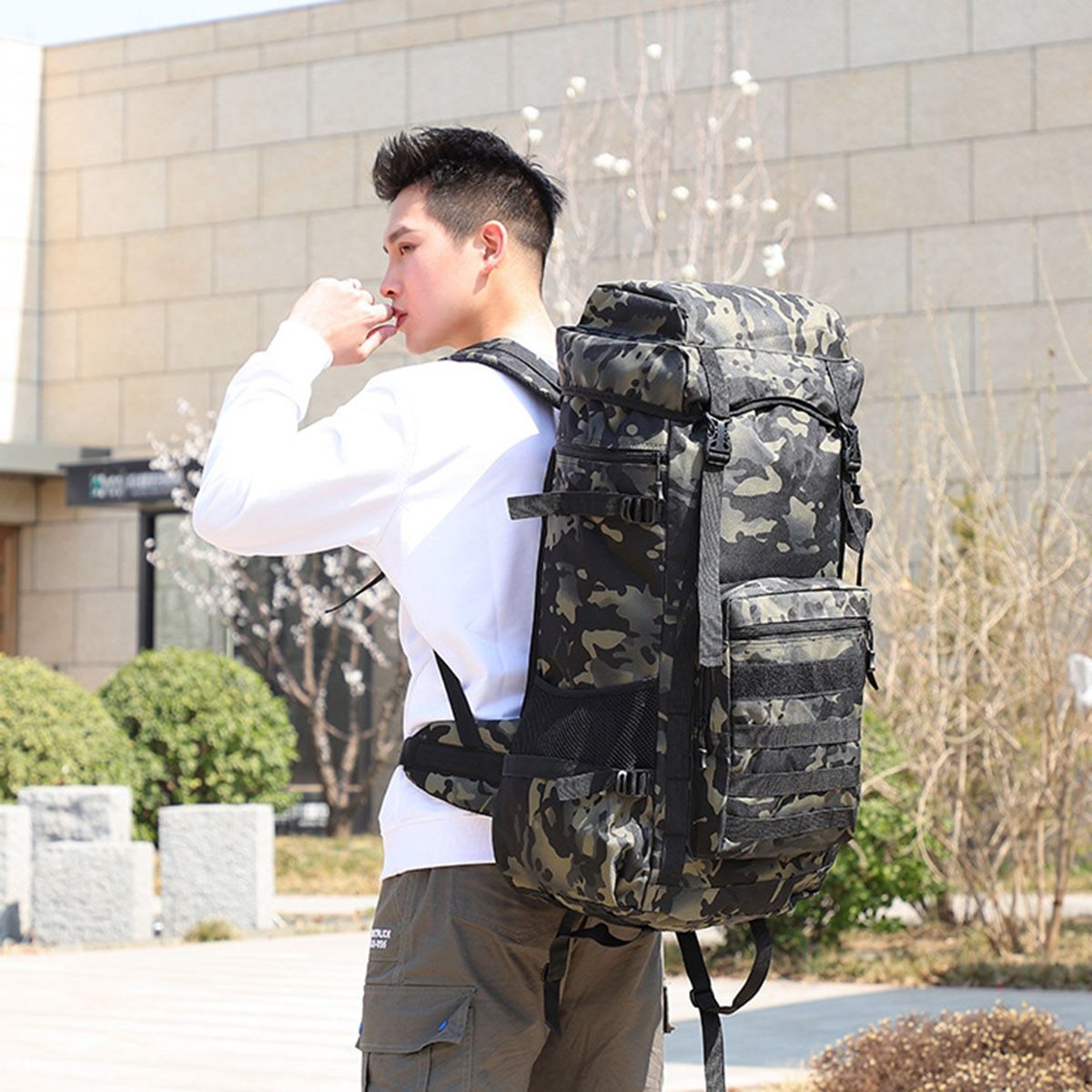 Man wearing a waterproof military backpack 70L in camouflage design, perfect for camping trips